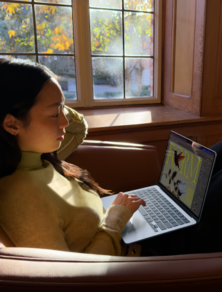 Una persona sentada en una silla usa una MacBook Air